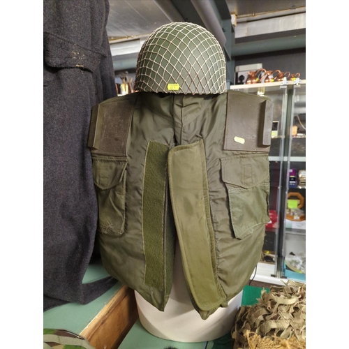 269 - Large quantity of assorted military clothing inc. flack jacket, four helmets, two hats and a wool gr... 