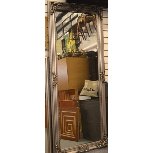 302 - Very large bevelled mirror in an ornate silver frame. 210cm x 87cm.