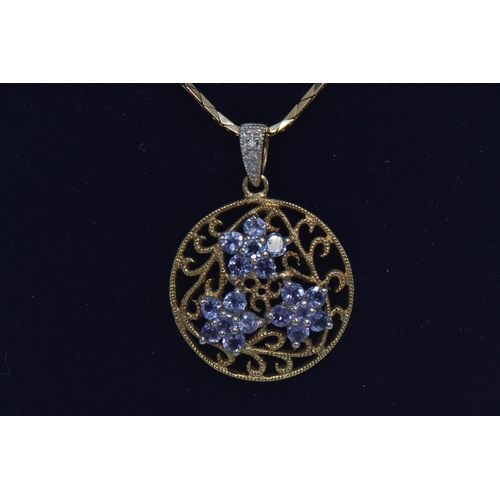 77 - 9ct gold, tanzanite & diamond circular open work pendant with a 9ct gold chain, pendant length i... 