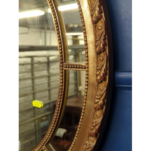 425 - Gilt framed oval mirror with mirrored border, 67.5 x 53cm