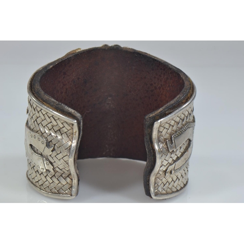 414 - Native American Navajo white metal cuff, the front with applied native American chief flanked by a n... 