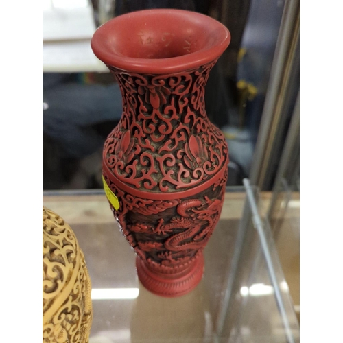 588 - Three cinnabar style oriental vases with dragon relief, height 22cm