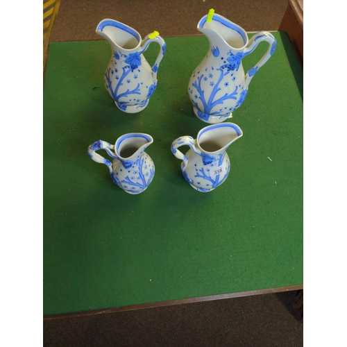 338 - Four graduated blue and white floral design jugs. largest 26cm high.