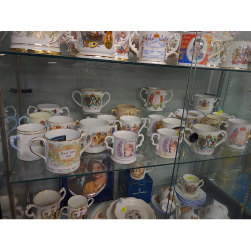 511 - Two shelves of Commemorative Loving Cups inc, Devon Ware, Royal Stafford, Aynsley and Royal Crown De... 