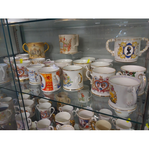 511 - Two shelves of Commemorative Loving Cups inc, Devon Ware, Royal Stafford, Aynsley and Royal Crown De... 