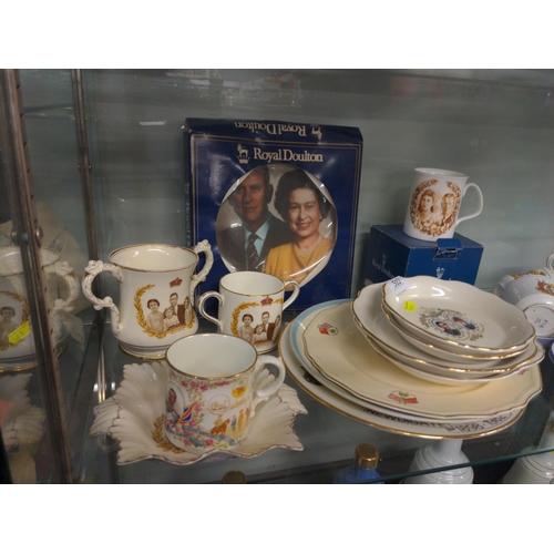 512 - Shelf of commemorative ware inc. part tea set ,plates and loving cups inc. Royal Winton ,Royal Doult... 