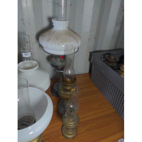 182 - Nine metal based oil lamps. Tallest 73 cm 