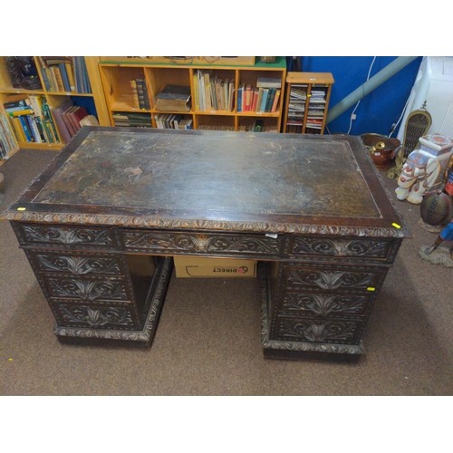 603 - Oak pedestal desk with leather inset on original wood & brass castors, drawers heavily carved wi... 