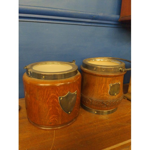 415A - Two oak biscuit barrels, both with ceramic liners and a central blank cartouche, height 15cm