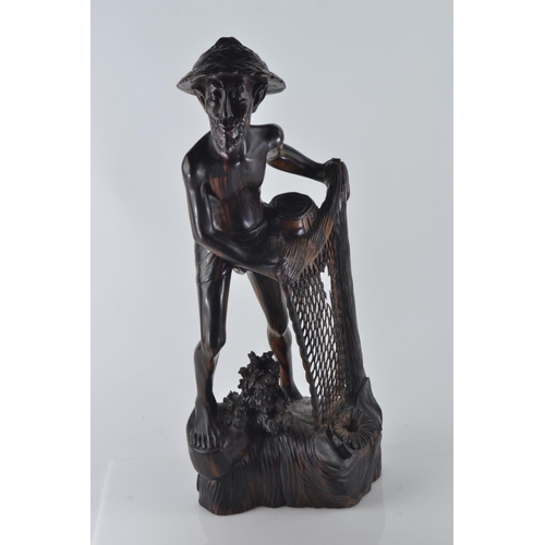 694 - Hardwood carved figure of a fisherman pulling his nets and catch from the water H50.5cm