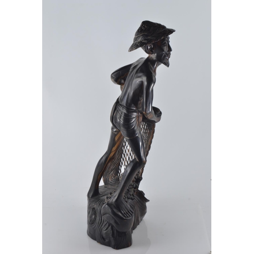 694 - Hardwood carved figure of a fisherman pulling his nets and catch from the water H50.5cm