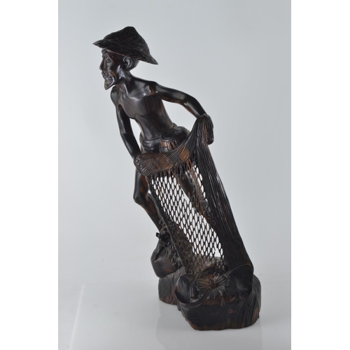 694 - Hardwood carved figure of a fisherman pulling his nets and catch from the water H50.5cm