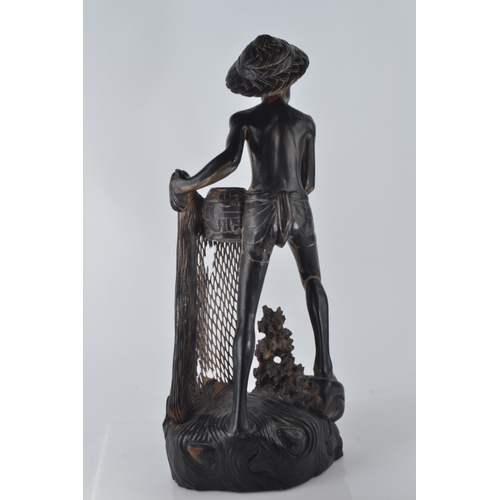 694 - Hardwood carved figure of a fisherman pulling his nets and catch from the water H50.5cm