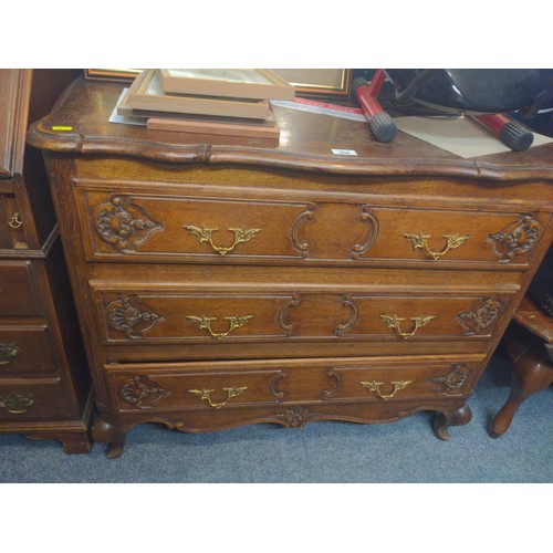 946 - An ornate 3 drawer chest with brass handles. 95cm long x 48cm deep x 80cm high