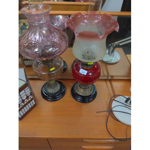 1051 - Two glass based oil lamps Tallest H56cm