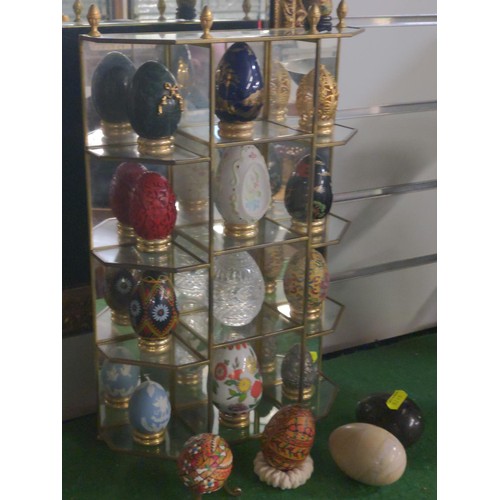 396 - Collection of decorative eggs and stands on a glass and mirrored display unit with 17 various sized ... 