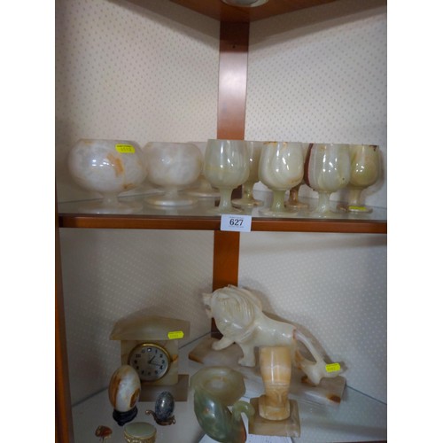 627 - Two shelves of onyx items inc. drinking vessels, lion and others.