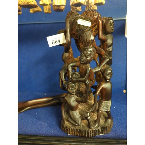 664 - African hardwood carving of a figural group and salad servers. 26cm tall