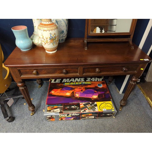 675 - Mahogany table/desk with two drawers and brass castors W 106 D53 H 74 cm