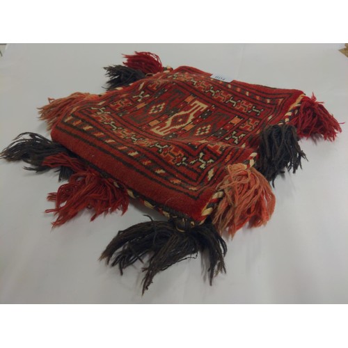 604 - Red ground rug bag, body length 30cm excluding tassels