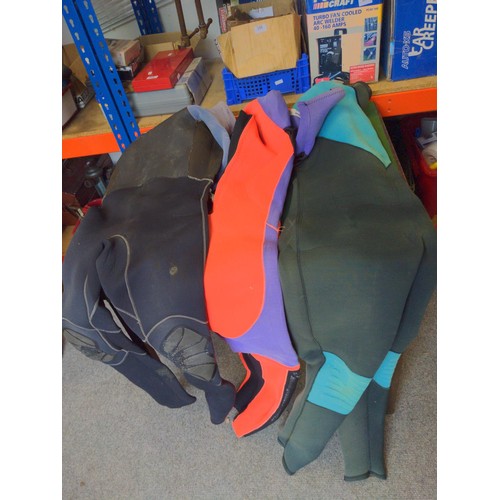 305 - Three wetsuits of various sizes and colours.