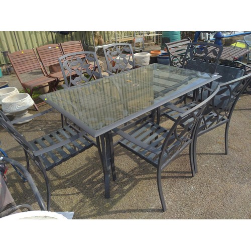 104 - Glass topped garden table, together with 6 matching metal framed chairs, with original seat cushions... 