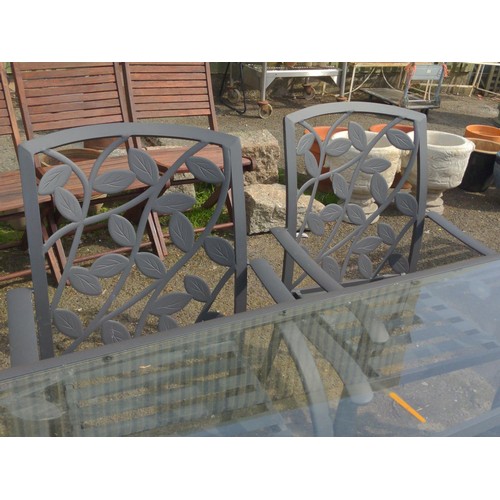 104 - Glass topped garden table, together with 6 matching metal framed chairs, with original seat cushions... 