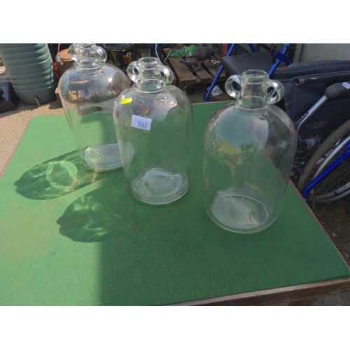 202 - Three glass demijohns H 32 cm