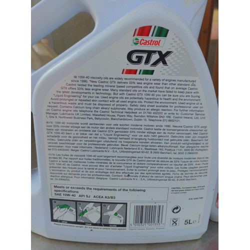 57 - 2 Castrol GTX 10W-40 oil bottles. One full, one part filled.