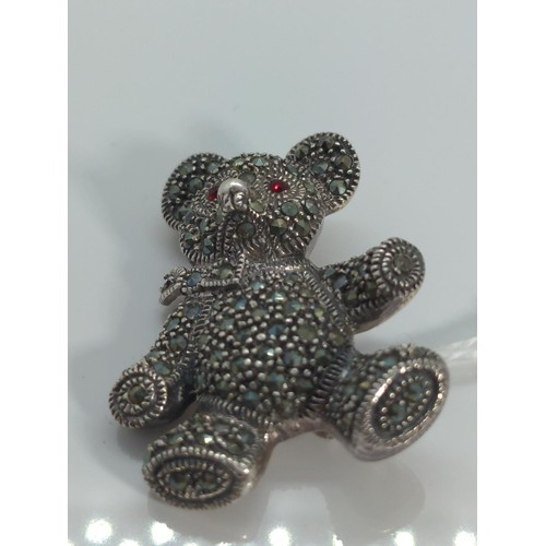 668 - 925 silver teddy bear brooch, set with red stone eyes and marcasite, length 37mm, gross weight 13.77... 