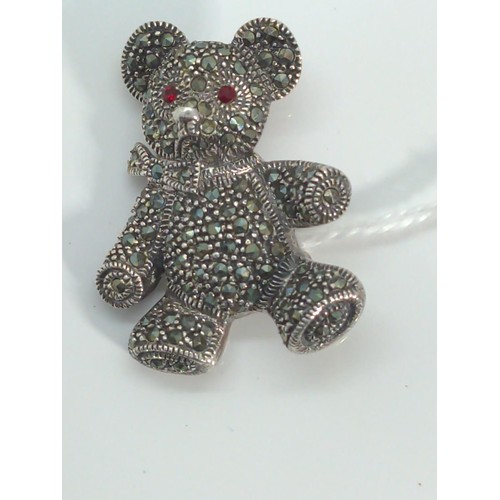 668 - 925 silver teddy bear brooch, set with red stone eyes and marcasite, length 37mm, gross weight 13.77... 