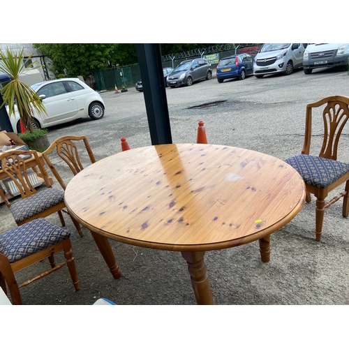 143 - Pine oval dining table and four upholstered chairs. Legs are removable