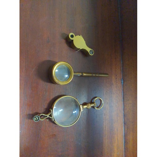 575 - Pair of gilt frame lorgnettes, together with a loupe and eye glass