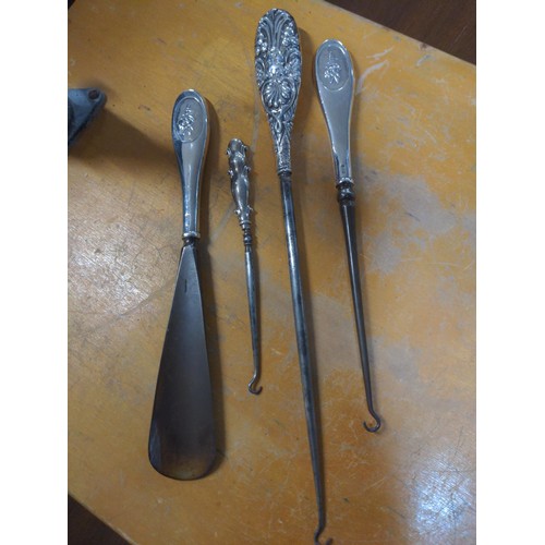 568 - Three hallmarked silver handled boot hooks and a shoe horn