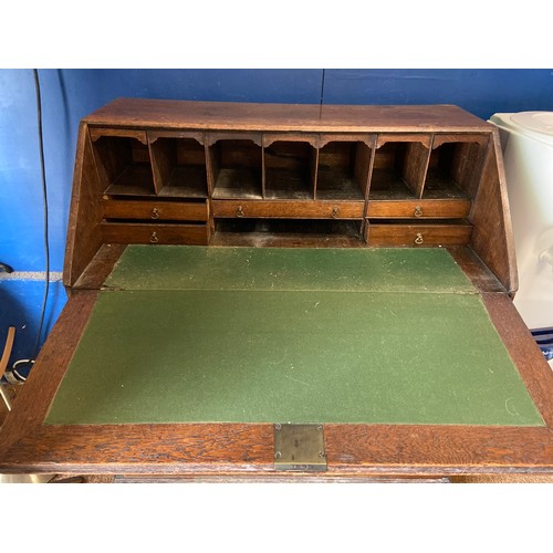 342 - Oak writing bureau with four drawers. Locks in place but no key. 