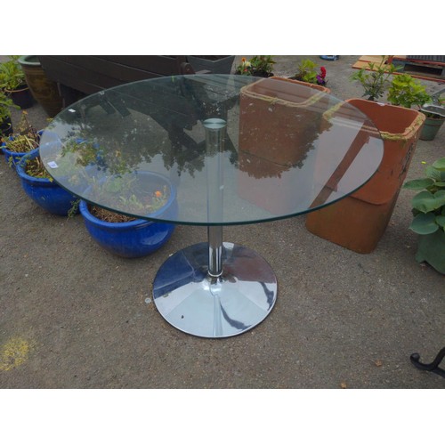 20 - Glass topped, chrome based dining table. D100cm