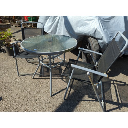 151 - Metal framed garden table & chairs. Table has glass top.