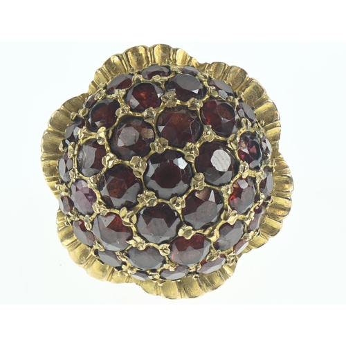 81 - 9ct gold and garnet dress ring of flower design, size N, gross weight 16.48 grams