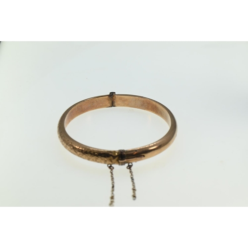 202 - 9ct gold hinged bangle, engraved scroll decoration to one side, hallmarked Chester 1900, inner width... 