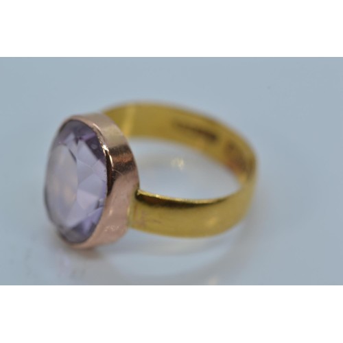 168 - 22ct gold band set with an oval-cut amethyst on yellow metal mount, size K, gross weight 3.22 grams