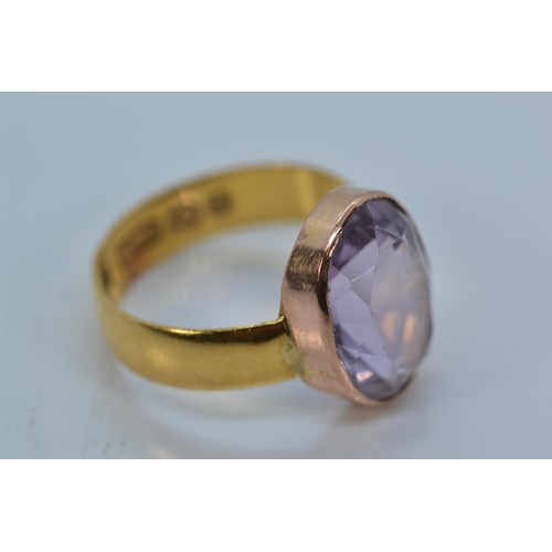 168 - 22ct gold band set with an oval-cut amethyst on yellow metal mount, size K, gross weight 3.22 grams