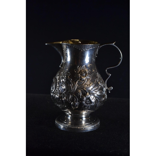 359 - George III silver cream jug, rubbing to London hallmarks, embossed with flowers and vacant cartouche... 