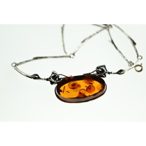 270 - Three pieces of amber set jewellery, including brooch, necklace and clip on earrings