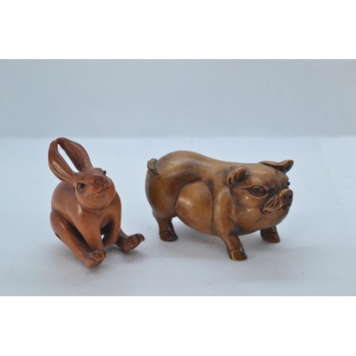 477 - Oriental carved boxwood pig, 7cm long. Together with a carved and signed hare netsuke, 5cm high.