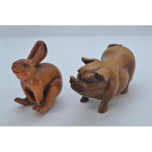 477 - Oriental carved boxwood pig, 7cm long. Together with a carved and signed hare netsuke, 5cm high.