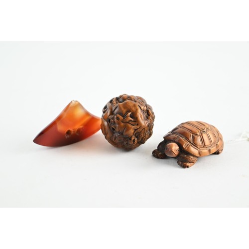 482 - Three Netsukes, including a tortoise, carved walnut and a polished stone in the form of a Netsuke