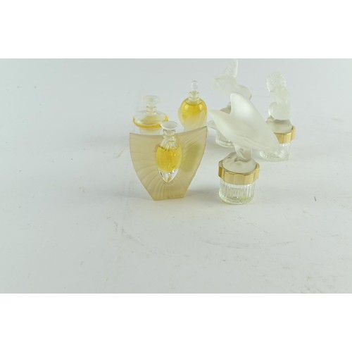 601 - Six Lalique miniature scent bottles, some with contents, one glass