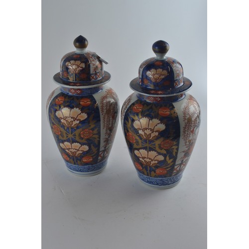 560 - Pair of Japanese Imari lidded vases with floral decoration, 33cm height to top of finial