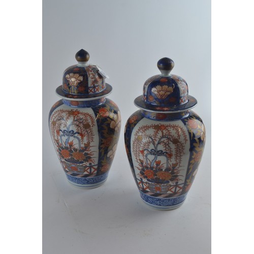 560 - Pair of Japanese Imari lidded vases with floral decoration, 33cm height to top of finial