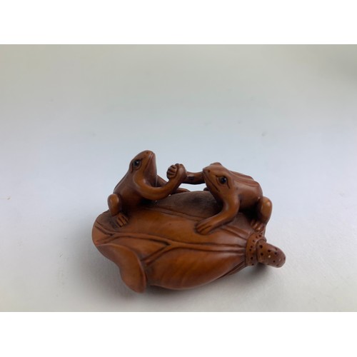 482A - Three hardwood carved frog netsukes, all with marks to base